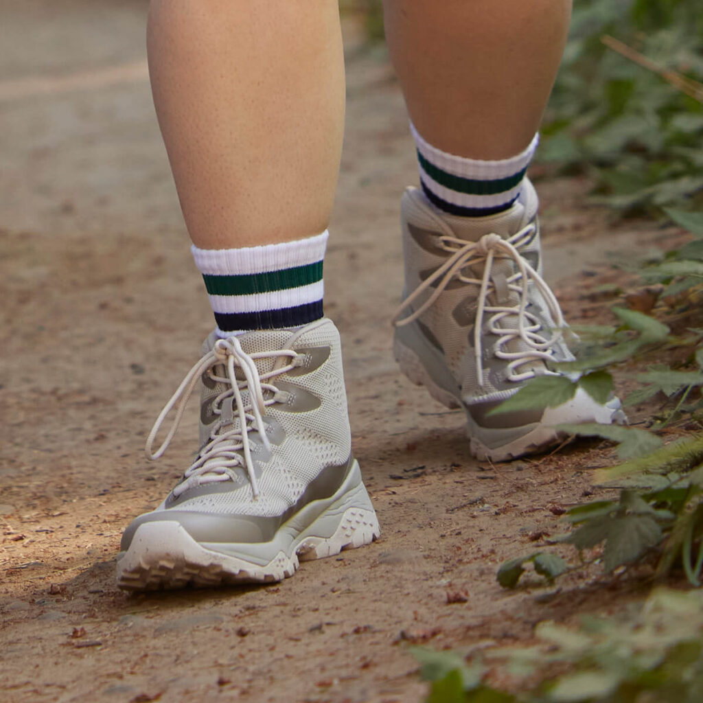gray hiking boot, striped socks, dirty trail