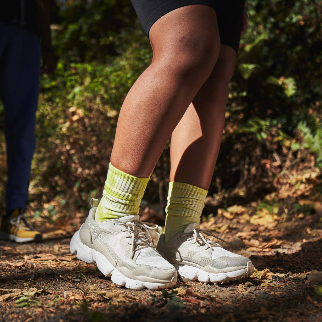 black woman on a trail in green socks and white shoes