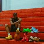 isaac okoro on bleachers with multiple colors of holo shoes